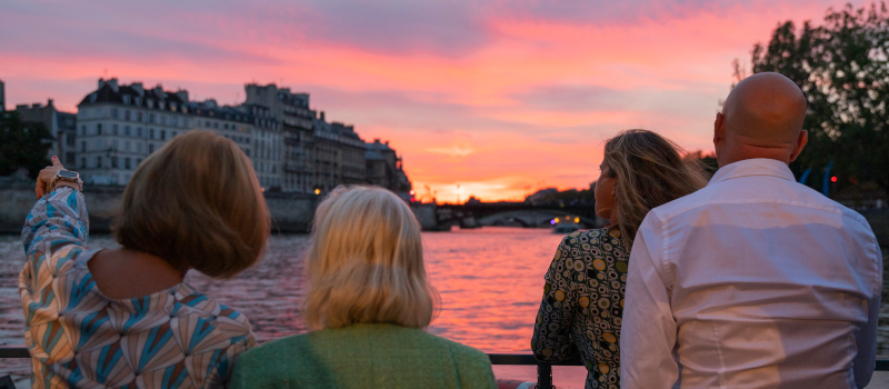 Parisiens contemplant un coucher de soleil sur la Seine.